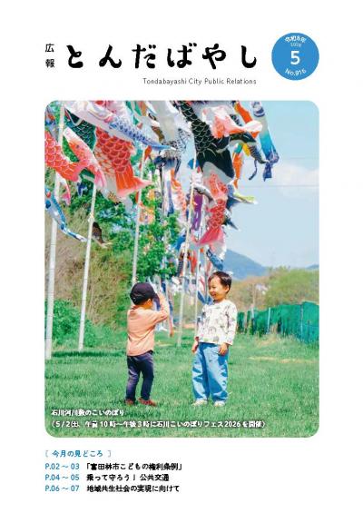 広報令和8年5月号表紙写真（石川河川敷の鯉のぼりと幼い兄弟）