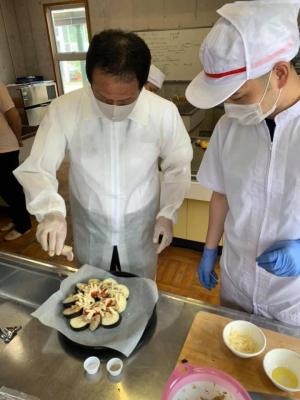 なす料理をする市長