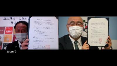 協定書を見せ合う市長と町長