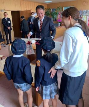 さくら元気保育園の園児が花を市長に渡す様子