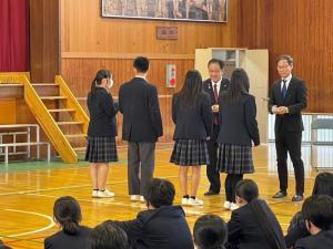 市内中学校でマンホールお守りカードを渡す様子